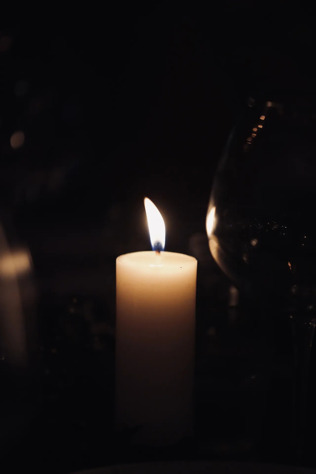 Single lit candle creating romantic ambiance at reception
