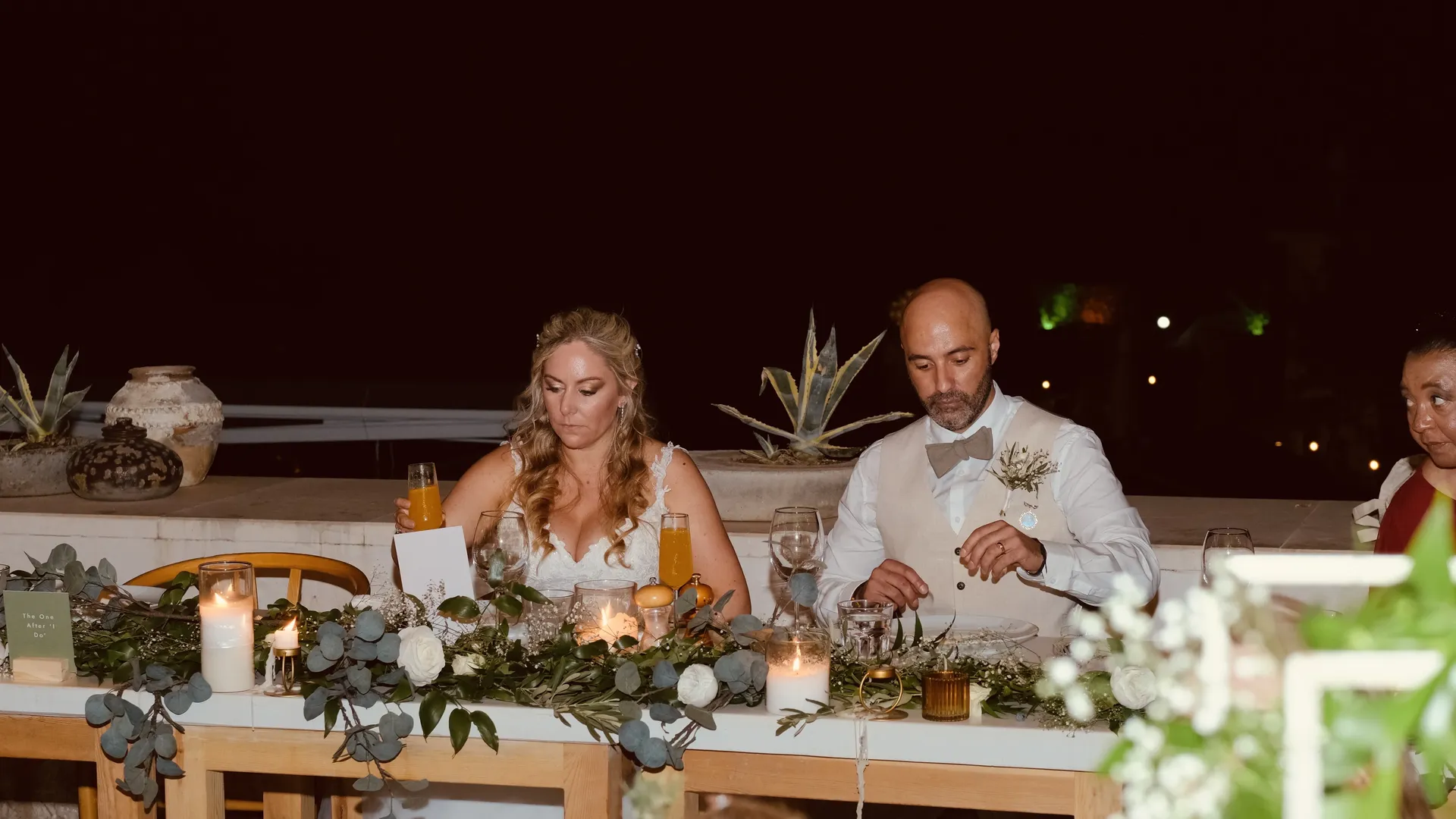 Couple at sweetheart table with eucalyptus garland styling