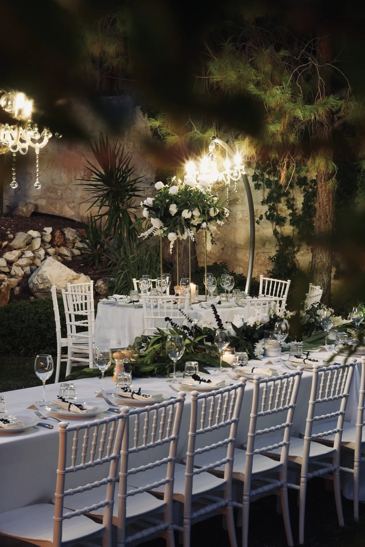 Garden reception setup with multiple tall floral arrangements