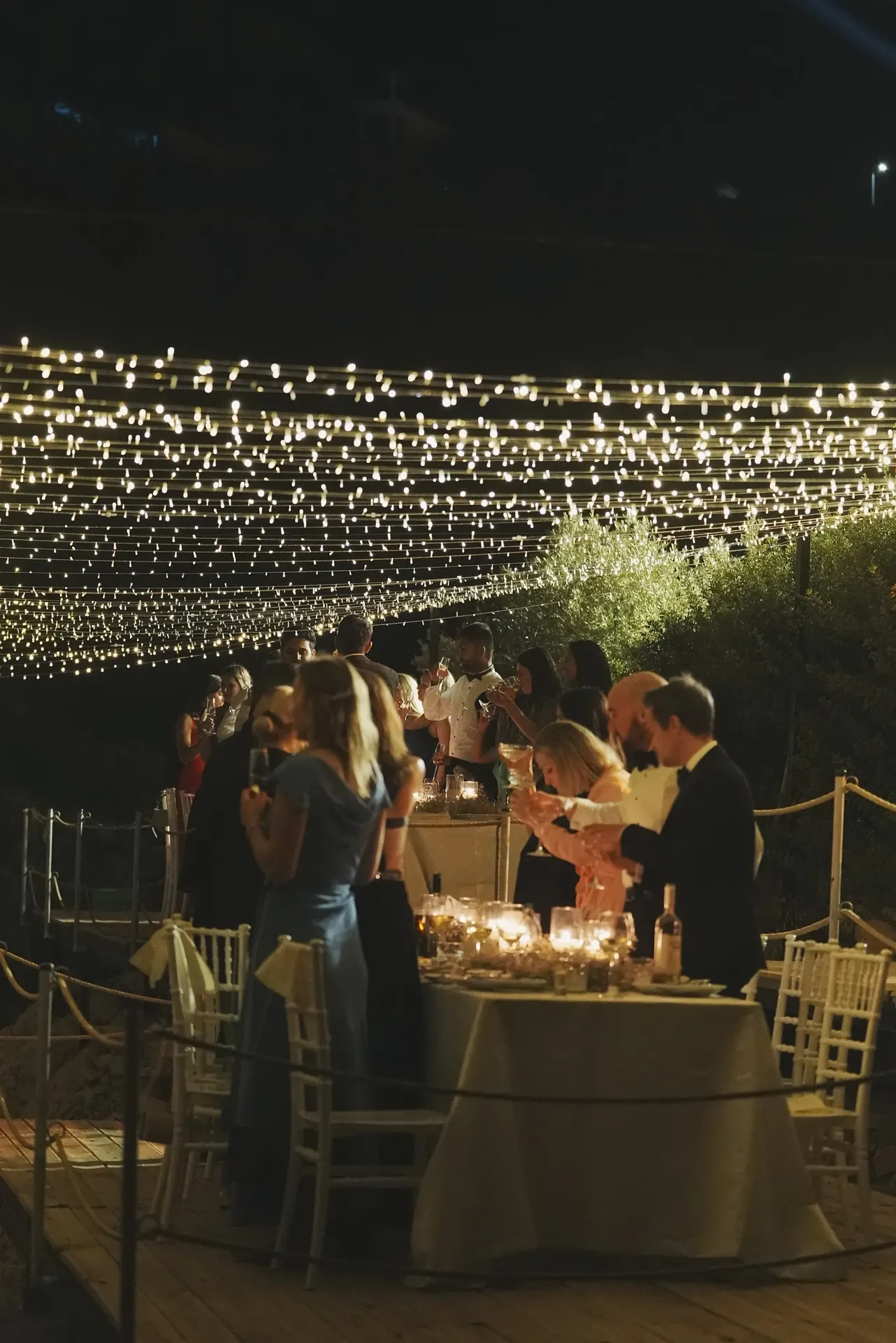 Guests toasting under dramatic string light waterfall