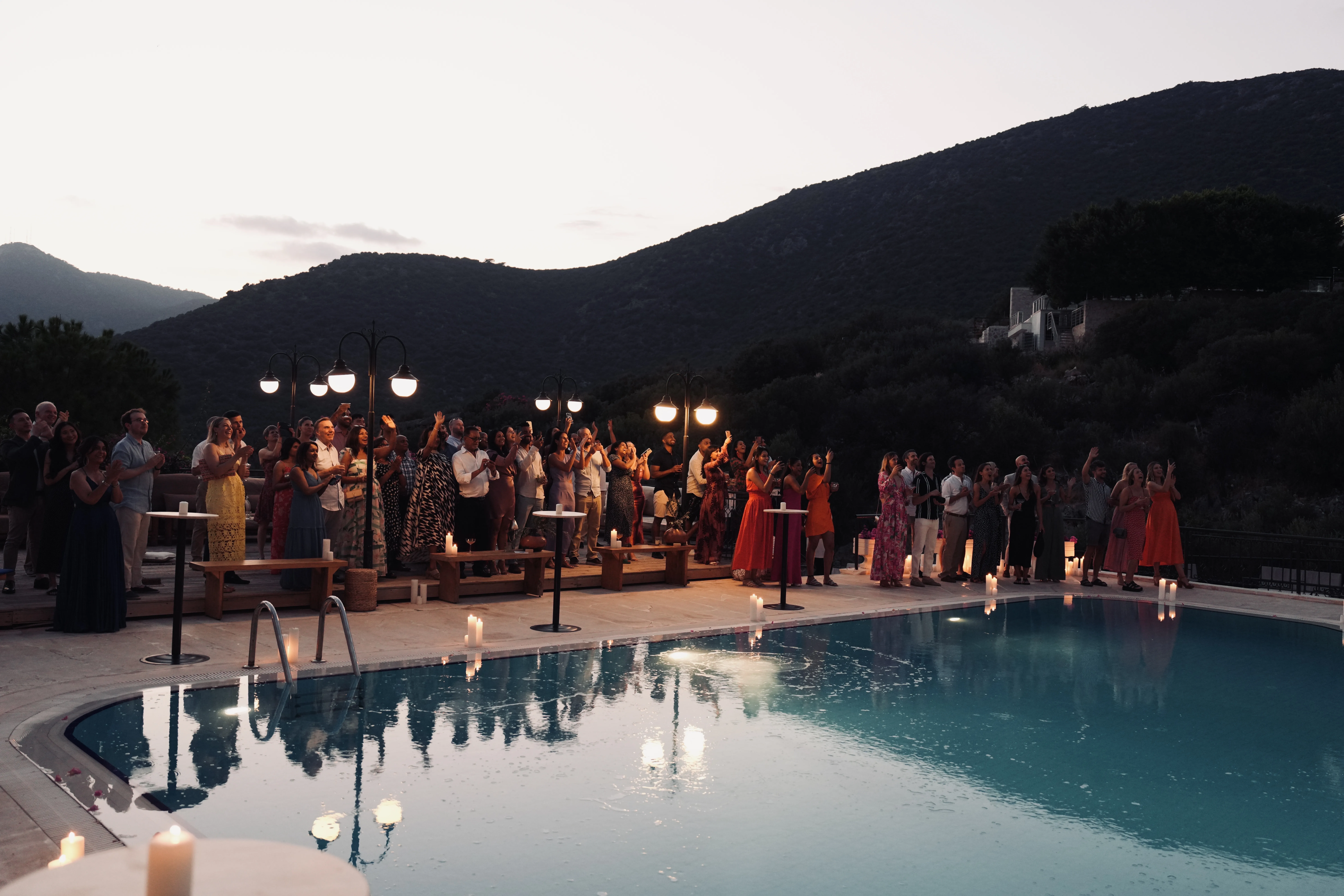 Candlelit poolside ceremony at dusk with mountain backdrop