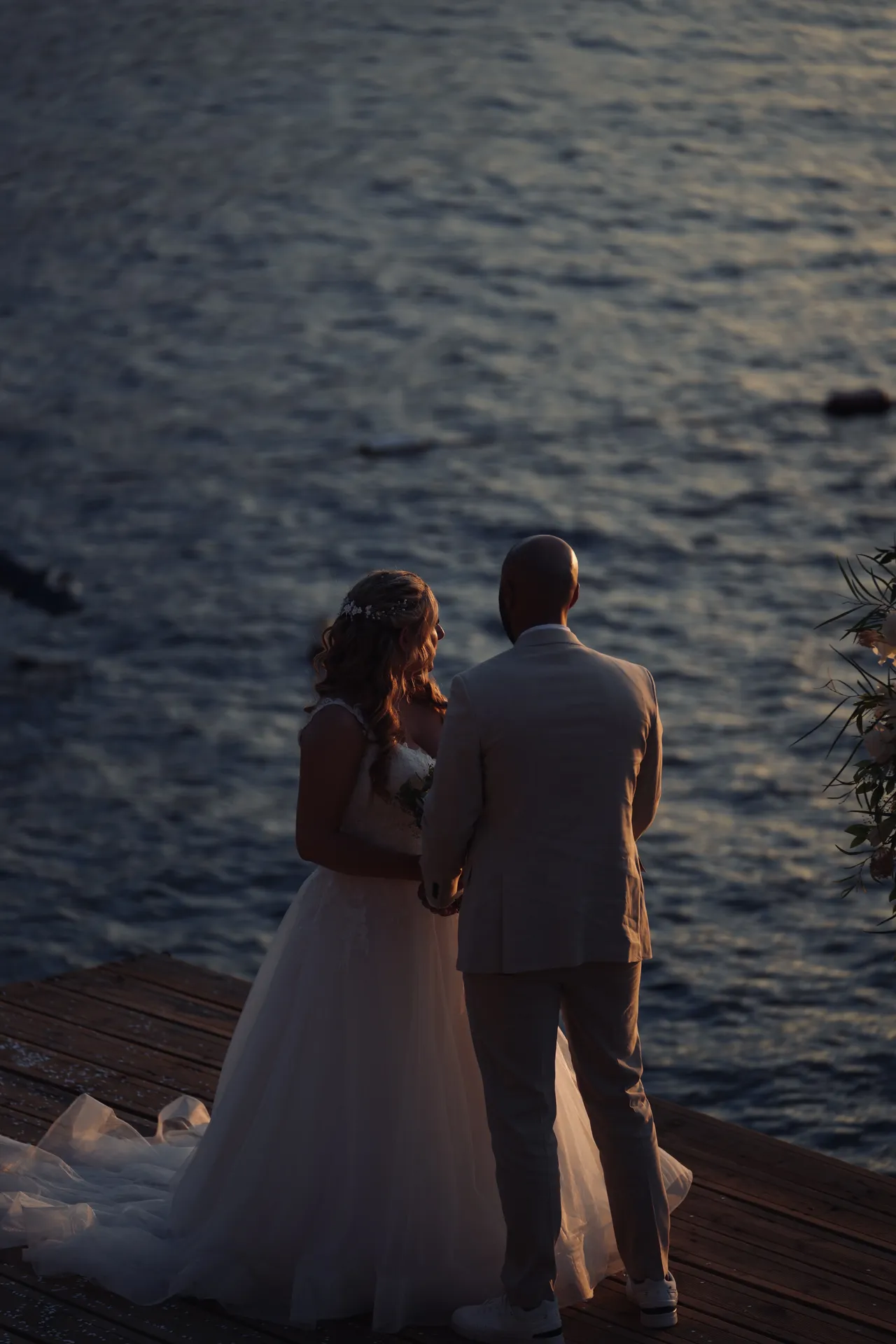 Couple silhouette against vibrant sunset on waterfront deck